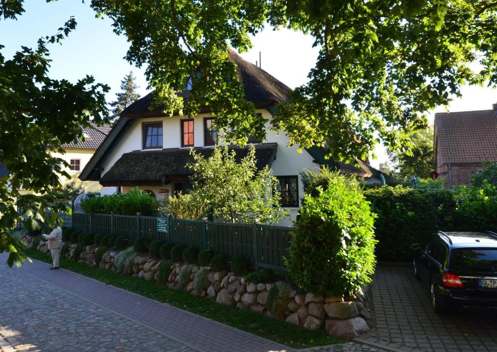 uma casa com uma cerca em frente em Ferienhaus-Strandflieder-in-Gross-Zicker-Halbinsel-Moenchgut em Groß Zicker