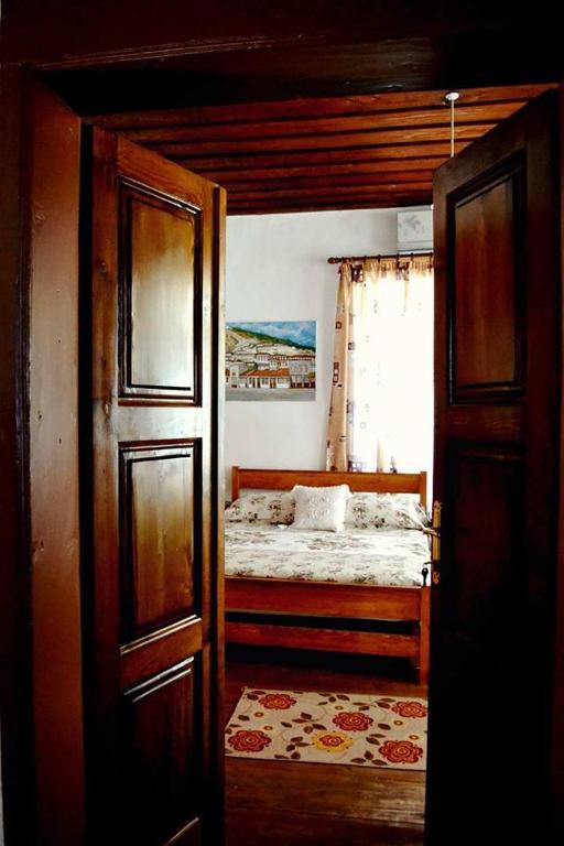 a bedroom with a bed and a window at Guest House Vasili in Berat