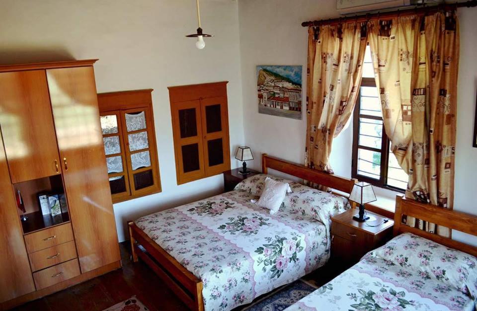a bedroom with two beds and a window at Guest House Vasili in Berat