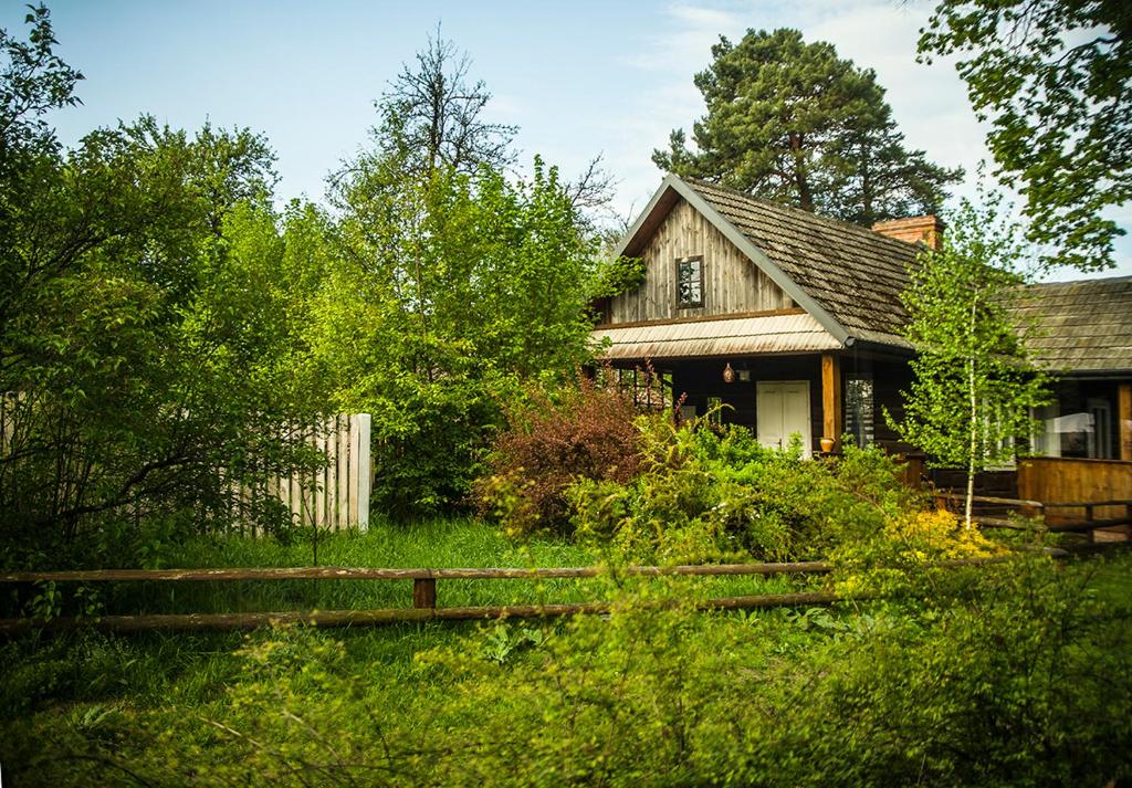 een oud huis met een hek ervoor bij Grenlanda in Ulanów