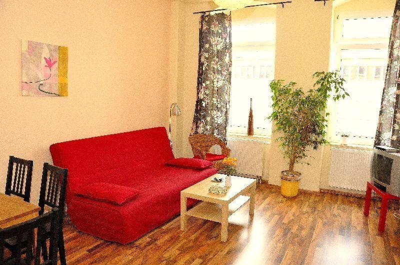 a living room with a red couch and a table at 3-Raum-Fewo-Dresden-Altstadt-L7 in Dresden