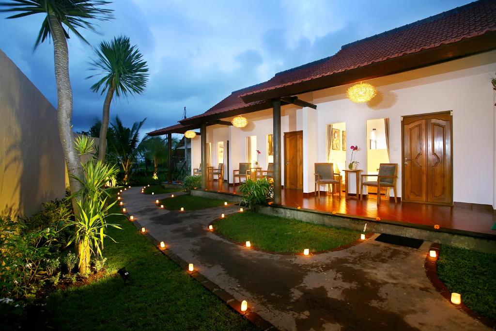 a house with a pathway leading to the front yard at Cokelat Guest House in Tanah Lot