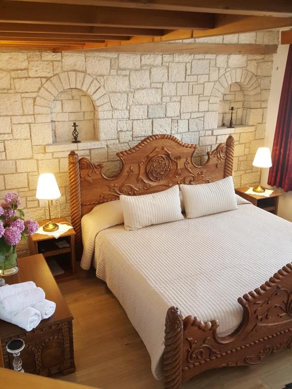 a bedroom with a bed and a lamp at Hotel Gjirokastra in Gjirokastër