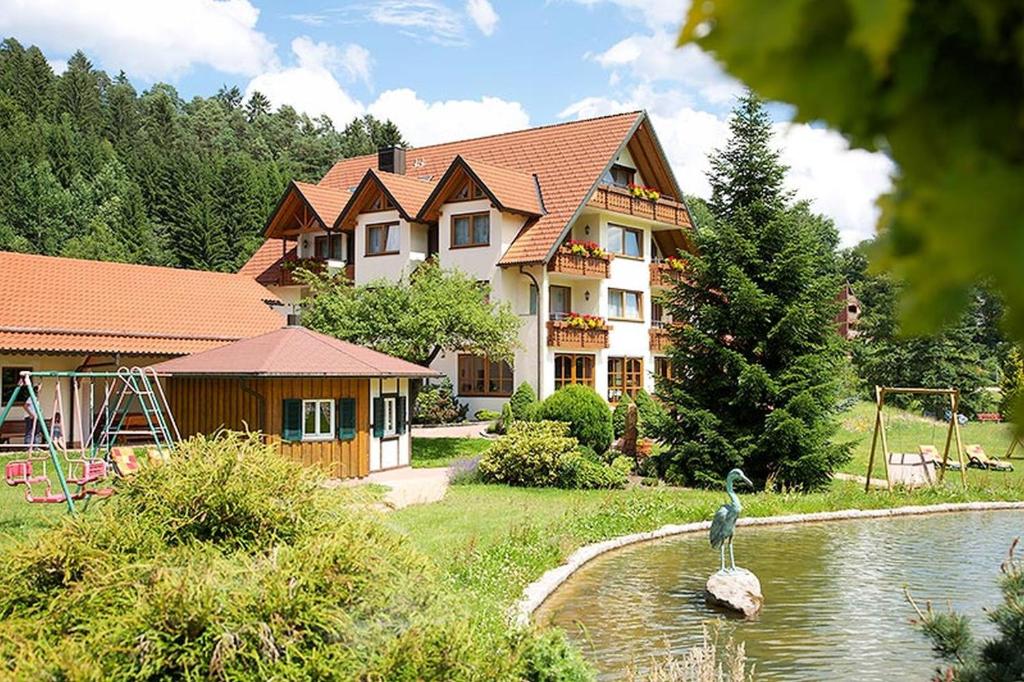 a large house with a bird standing in the water at Landhaus Mühlengrund in Baiersbronn