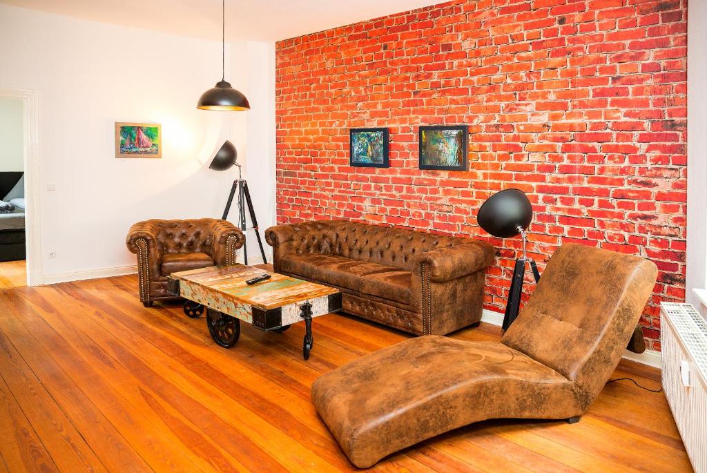 a living room with two couches and a brick wall at Uferpromenade in Waren