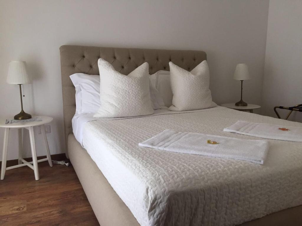 a white bed with two white towels on it at Bed & breakfast Frida in Catania