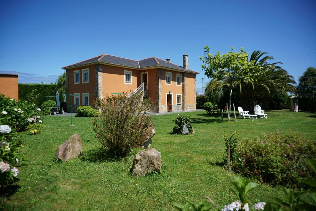 a house with rocks in front of a yard at Casa Gayol in El Franco