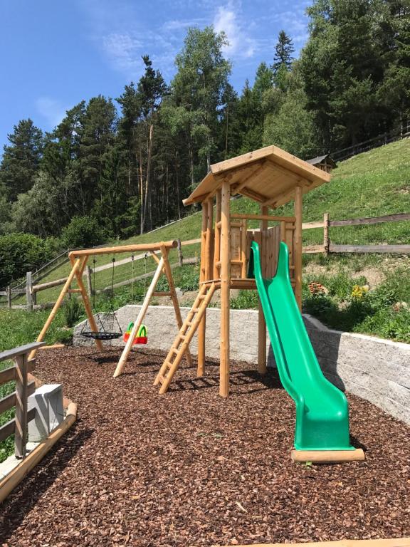 plac zabaw z dwoma huśtawkami i zjeżdżalnią w obiekcie Zehrehof w mieście Bressanone