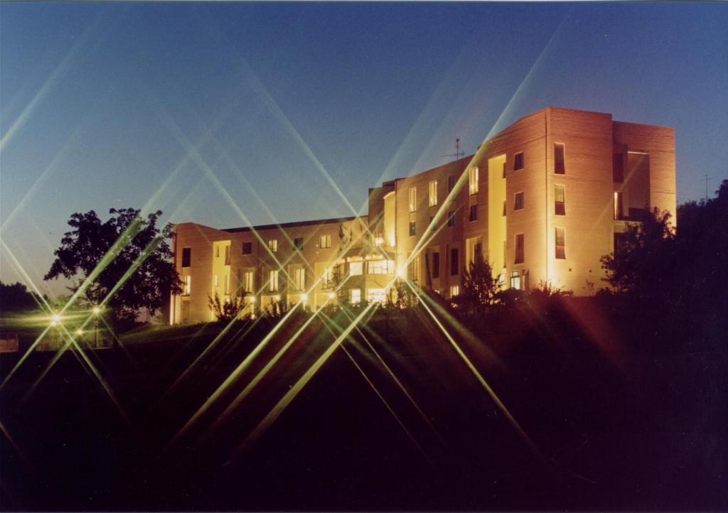 a large building with lights on in front of it at Hotel Palazzo dei Priori in Siena