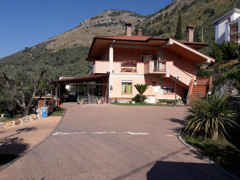 a large house with a mountain in the background at Solerosa in Fondi