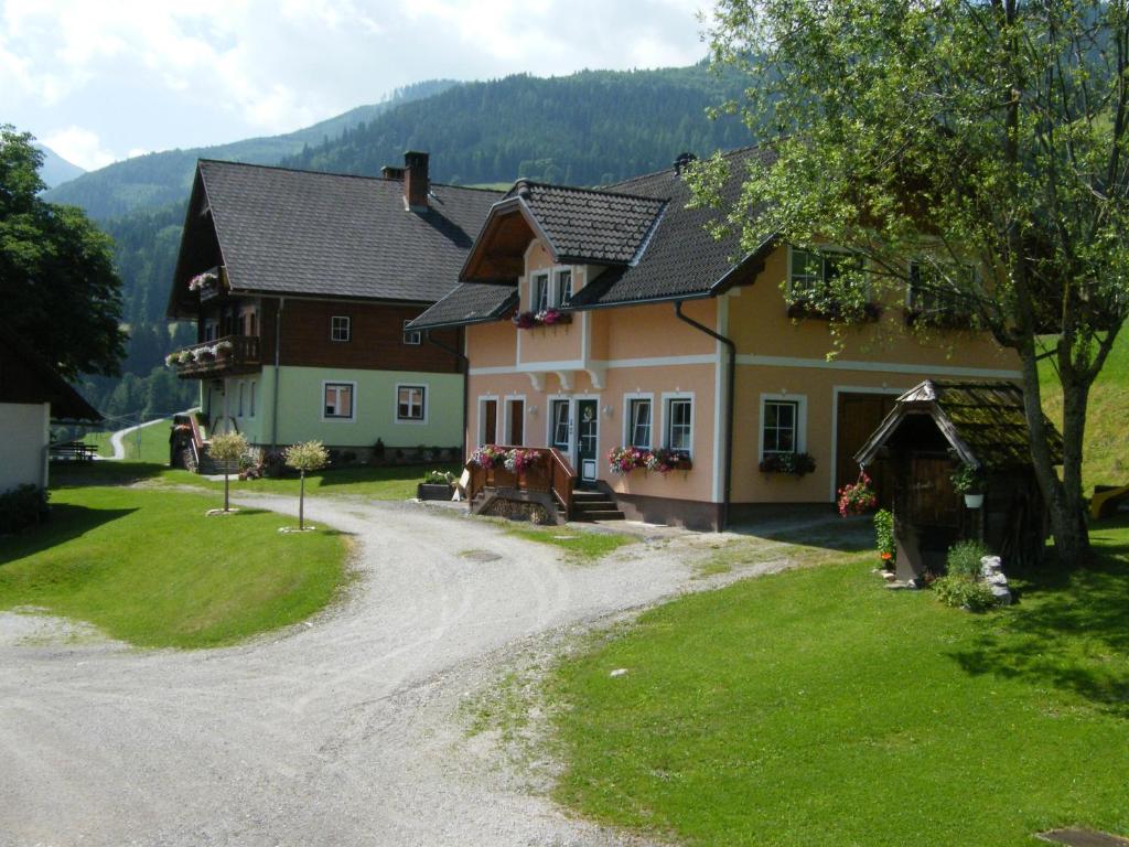 uma casa com um cavalo numa estrada de terra em Hintereggerhof em Pruggern