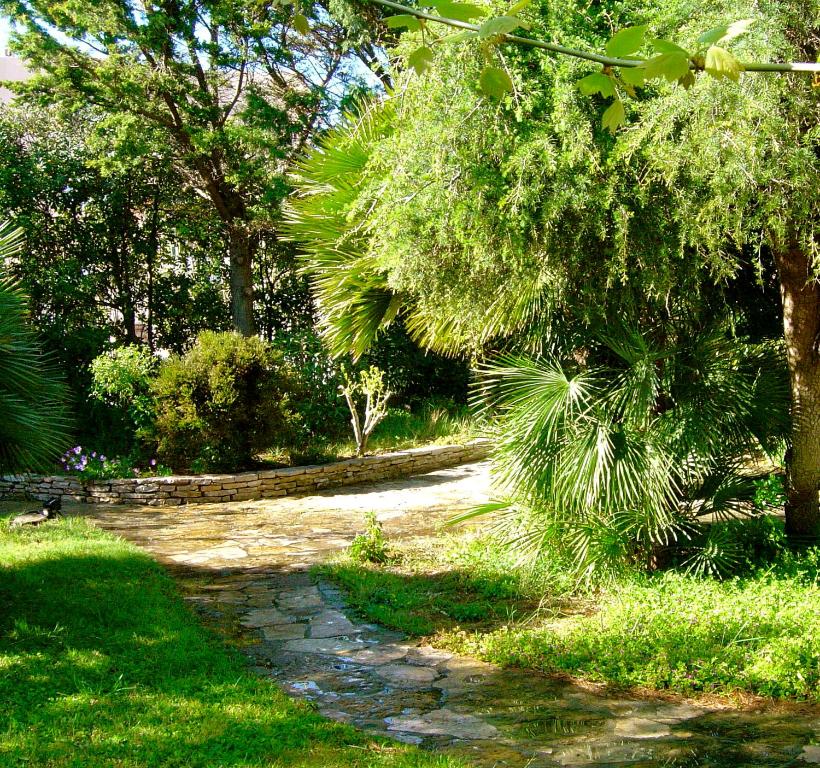 a stone path in a park with trees and grass at Villa Roka in Six-Fours-les-Plages
