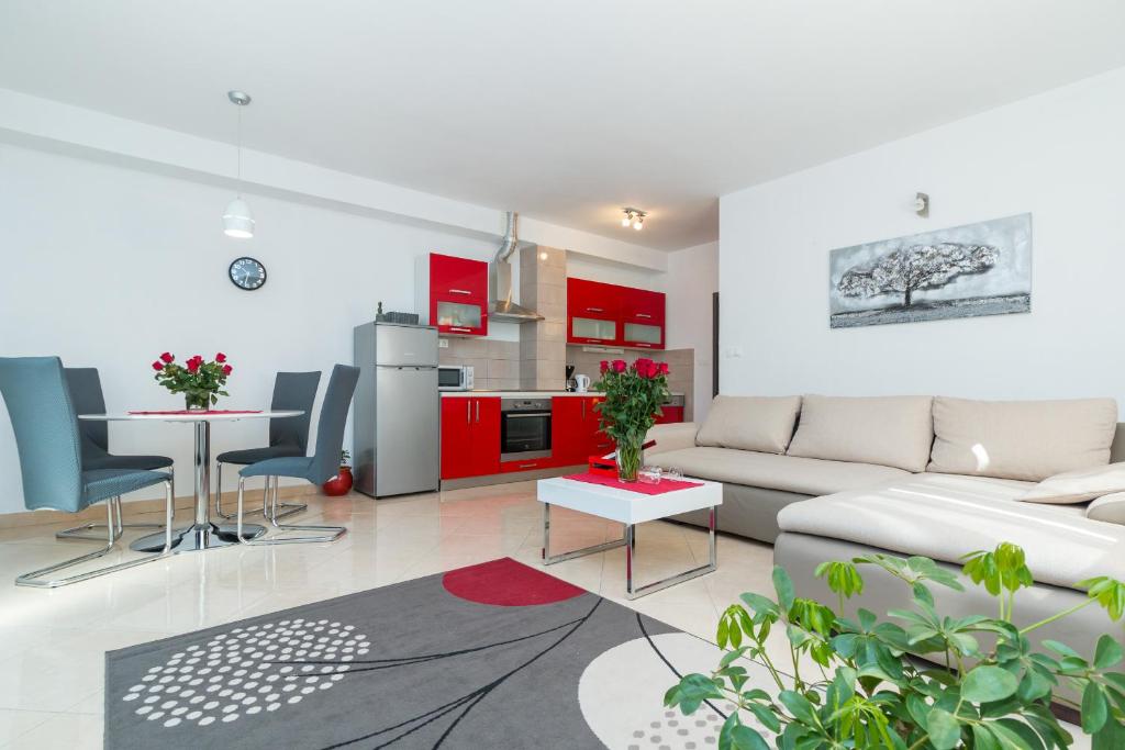 a living room with a couch and a table and a kitchen at APARTMENT JURAŠIN in Kaštela