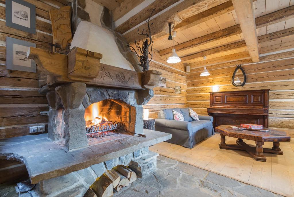 a living room with a fireplace in a log cabin at Osada Pienińska in Krościenko