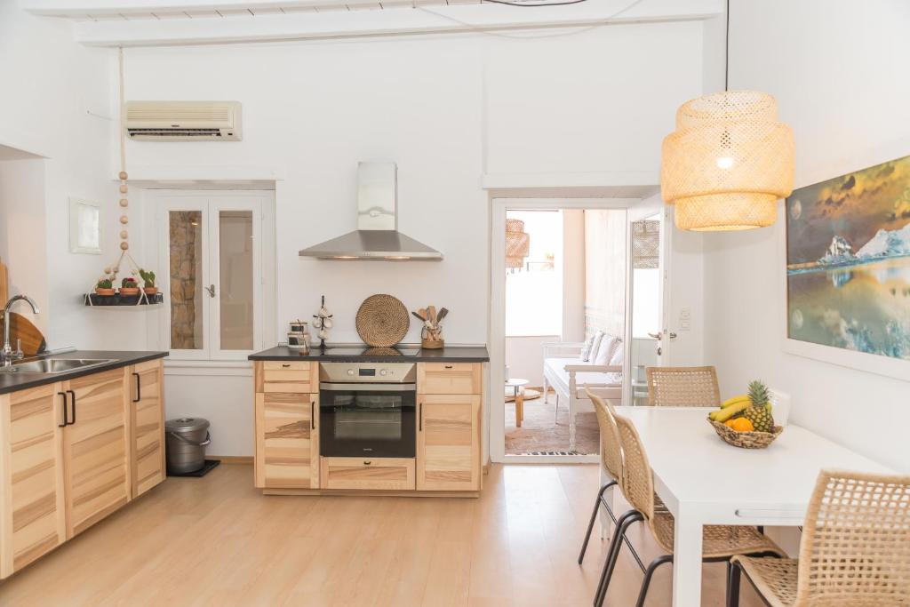 a kitchen and dining room with a table and chairs at Aretousa Deluxe Downtown Apartment in Skala