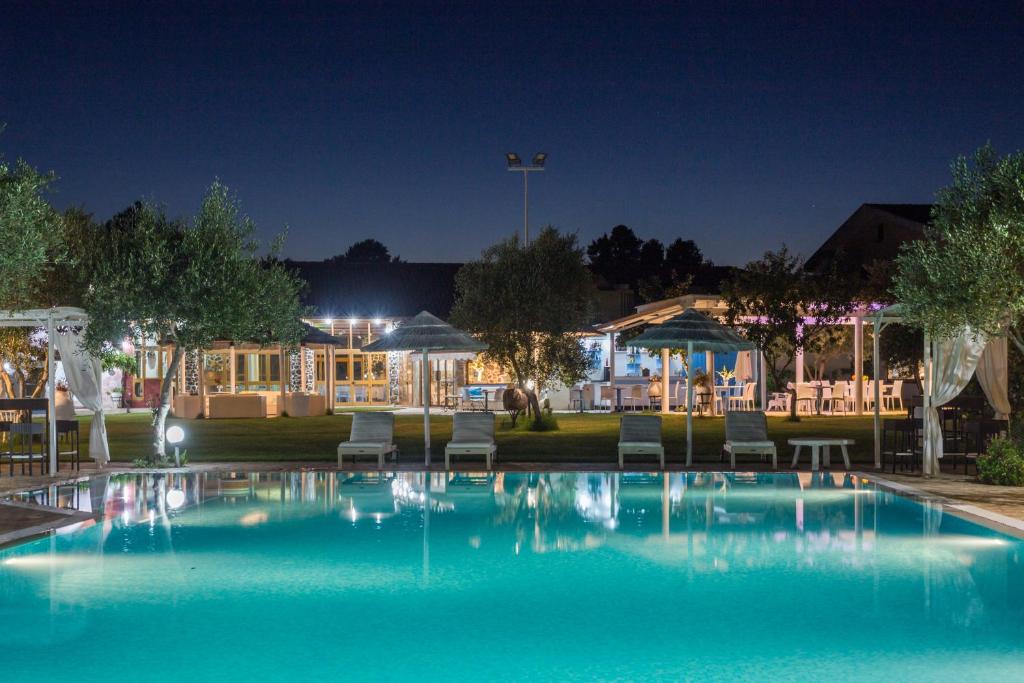 una piscina por la noche con sillas y sombrillas en Locanda Da Renzo, en Siamaggiore