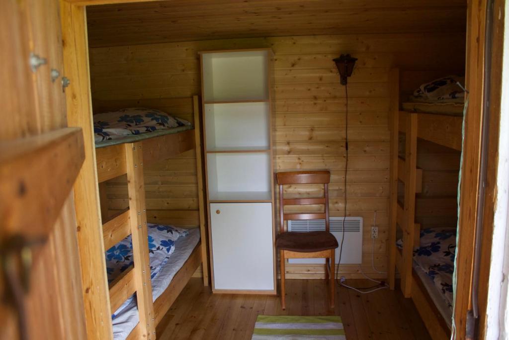 MoksinkyläにあるSurkeenjärvi Traditional Aittaの二段ベッド2台と椅子が備わる客室です。