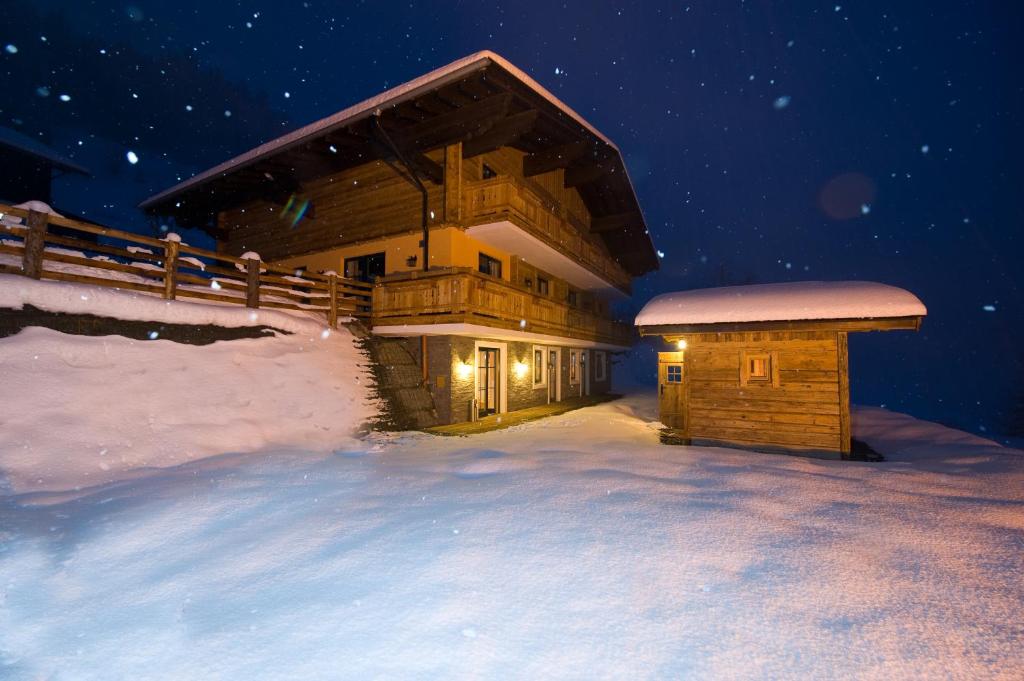 ein Blockhaus im Schnee in der Nacht in der Unterkunft Panorama Pension in Großarl