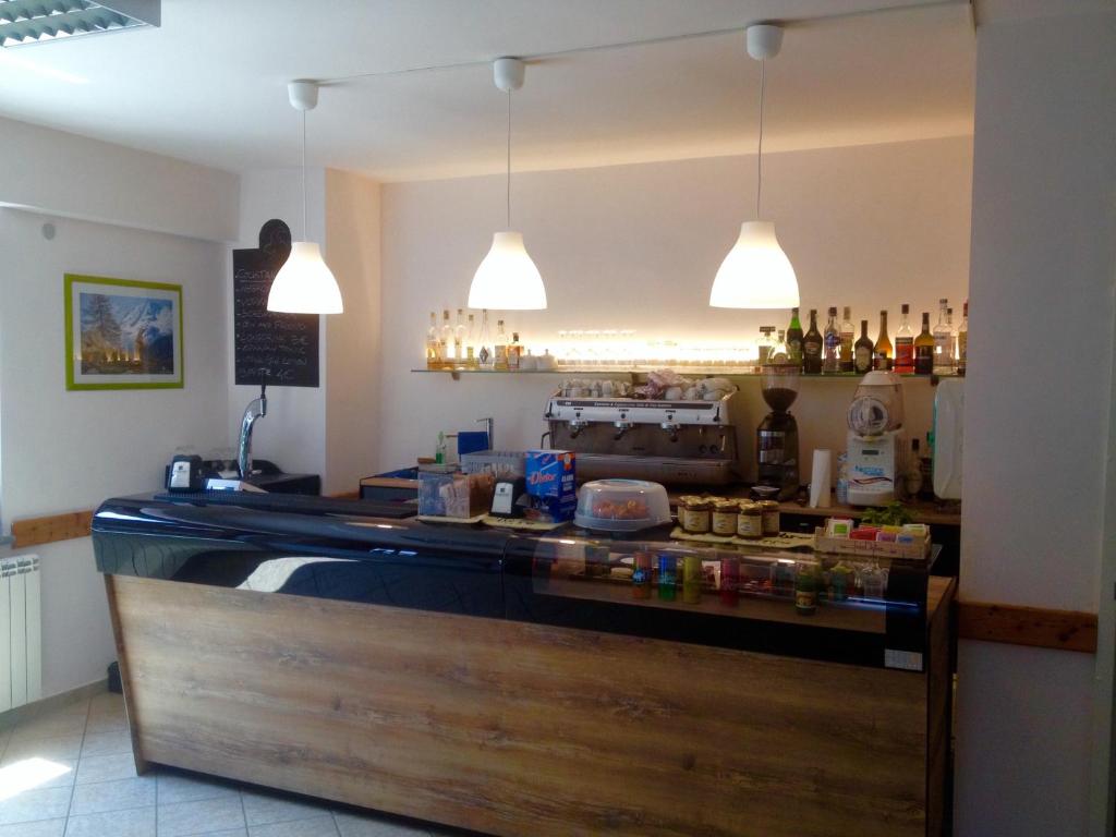 a counter in a restaurant with two pendant lights at Spazio Gran Paradiso Guest House in Alpette