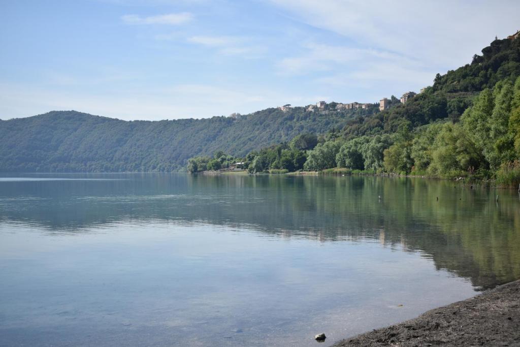 vista su un lago con alberi e montagne di In villa a Rocca di Papa