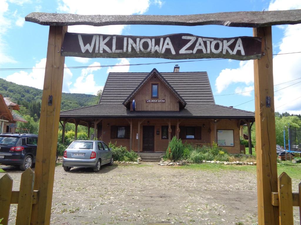 Un cartello che dice Willuminati Zaza di fronte a una casa di Wiklinowa Zatoka a Wetlina
