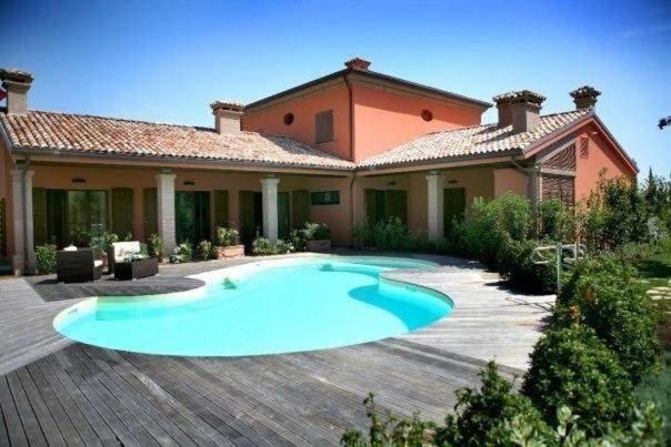 a large swimming pool in front of a house at Agriturismo La Pecora Nera in Mulazzano
