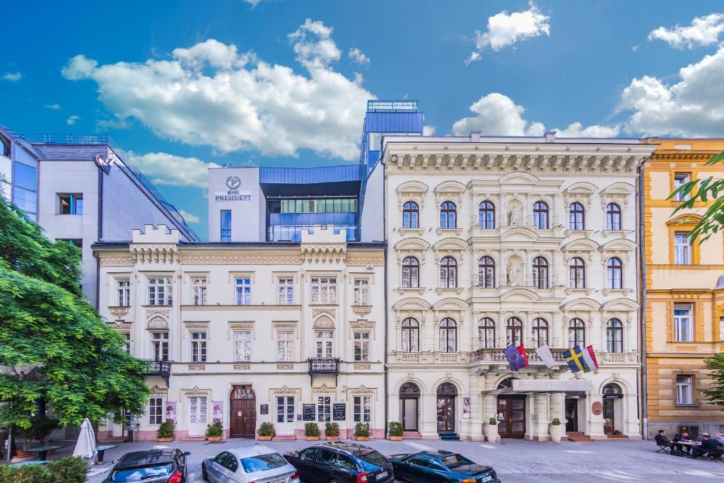 a large white building with cars parked in front of it at Hotel President in Budapest