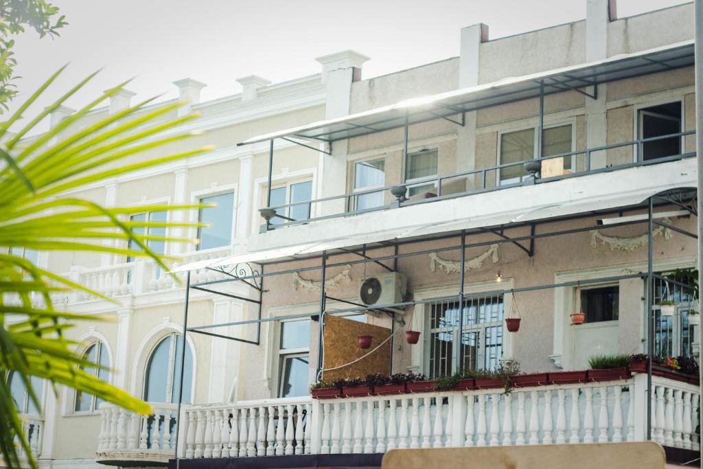een groot wit gebouw met een balkon bij Guest House Esma in Soechoemi