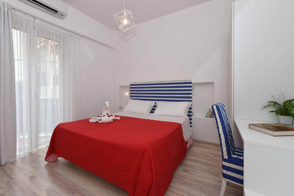 - une chambre avec un lit et une couverture rouge dans l'établissement CDA Apartament, à Minori