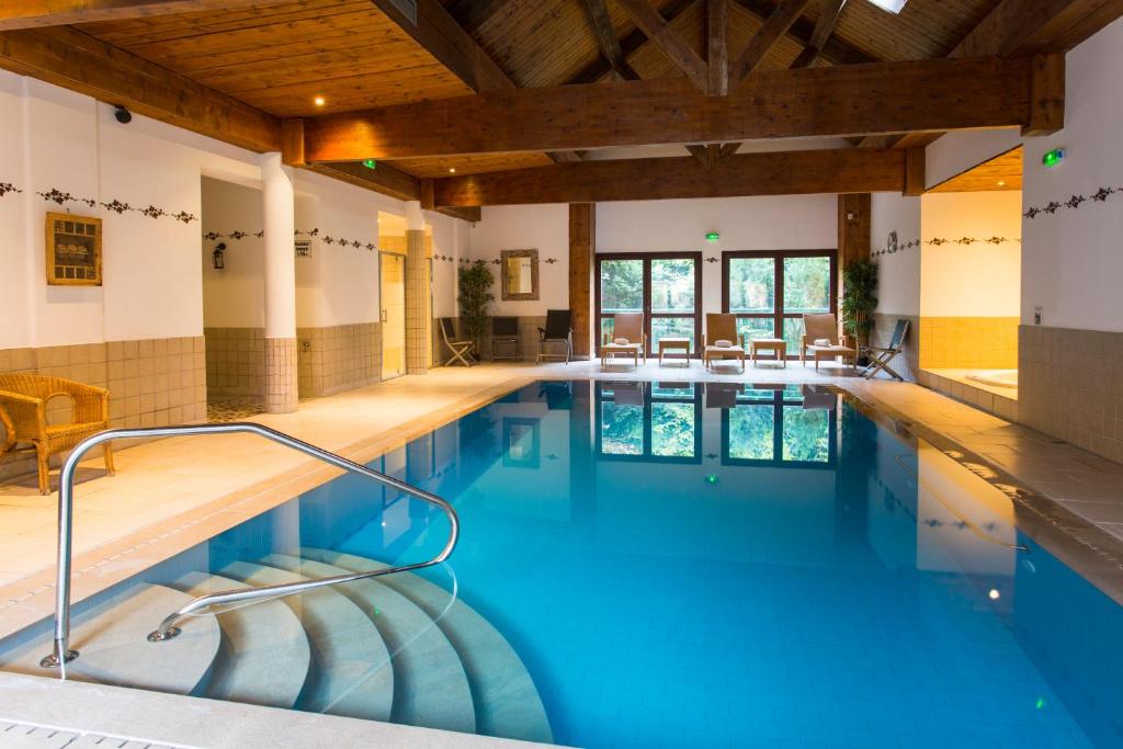 a swimming pool with blue water in a building at Le Domaine de Rouffach in Rouffach