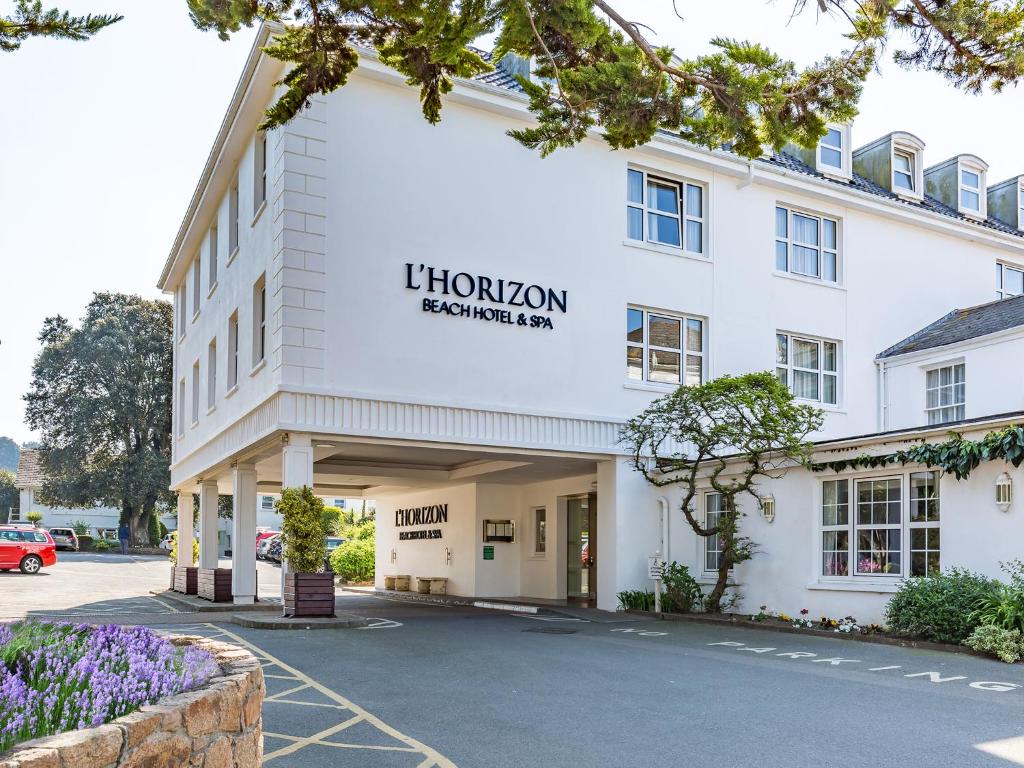 un gran edificio blanco con un cartel que lee Lion inn Scarborough en L’Horizon Beach Hotel & Spa en St Brelade