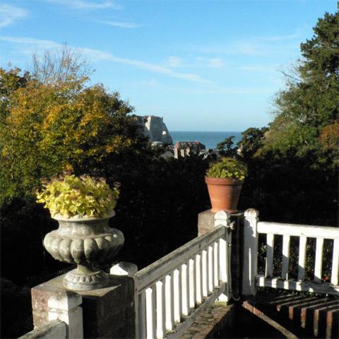 une clôture blanche avec deux plantes en pot dans l'établissement Chambres d'Hôtes les Charmettes, à Étretat