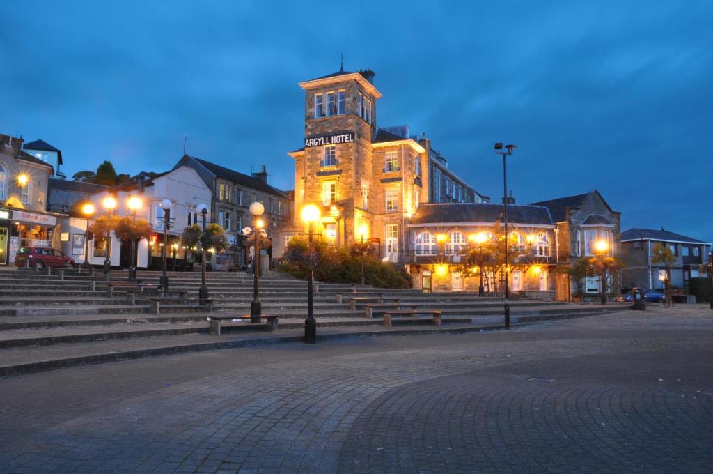 a large building with stairs and a clock tower at night at Argyll Hotel in Dunoon