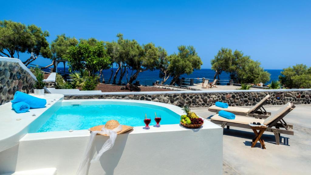 a villa with a pool and a view of the ocean at Aronia Villa in Imerovigli