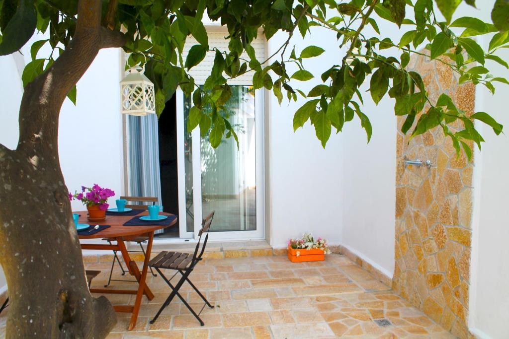 a dining room with a table and a tree at Kennedy House in Novoli