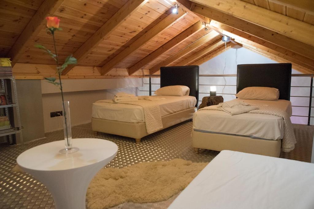 Zimmer mit 2 Betten und einem Tisch mit Vase in der Unterkunft Odysseos St. Loft in Vathy