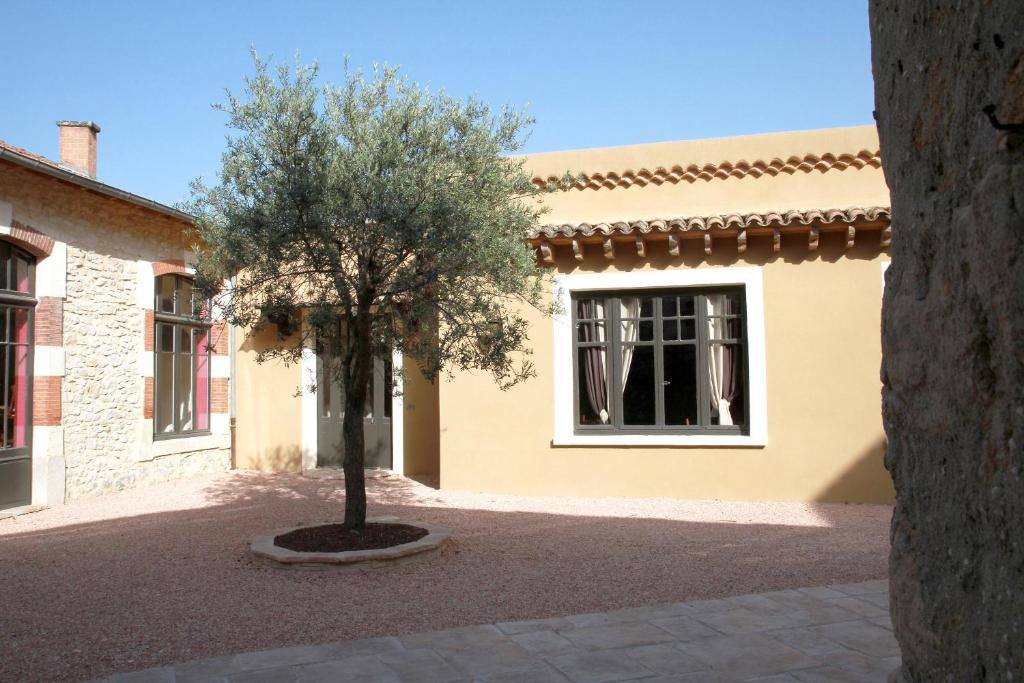 a tree in the courtyard of a house at Logis Hotel Le Clos Des Oliviers in Bourg-Saint-Andéol