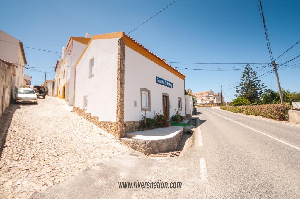 a small white building on the side of a road at Rivers Nation Surf Camp in Atouguia da Baleia