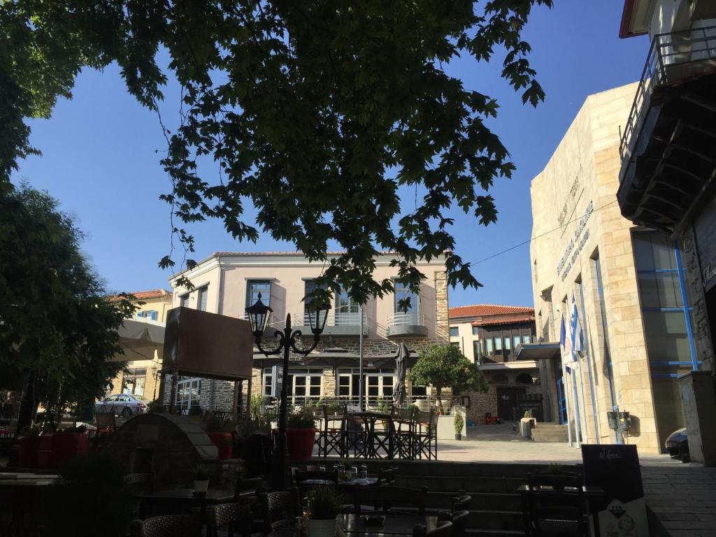 a building on a street with tables and chairs at Klities Guest House in Poligiros