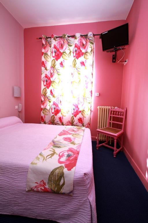 a pink room with a bed and a flower curtain at Logis Hotel Le Clos Des Oliviers in Bourg-Saint-Andéol