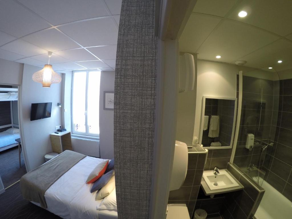 ディナールにあるCit'Hotel Les Alizesのベッドとバスルーム付きのホテルルームです。