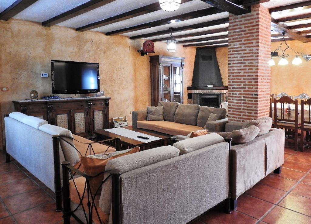 a living room with couches and a flat screen tv at Casa Rural Majada Palentina in Villanueva de Arriba