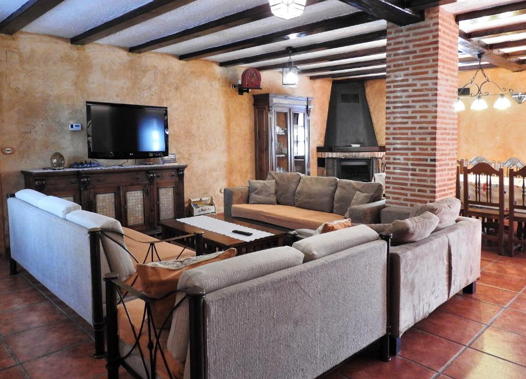 a living room with couches and a flat screen tv at La Majada Palentina in Villanueva de Arriba