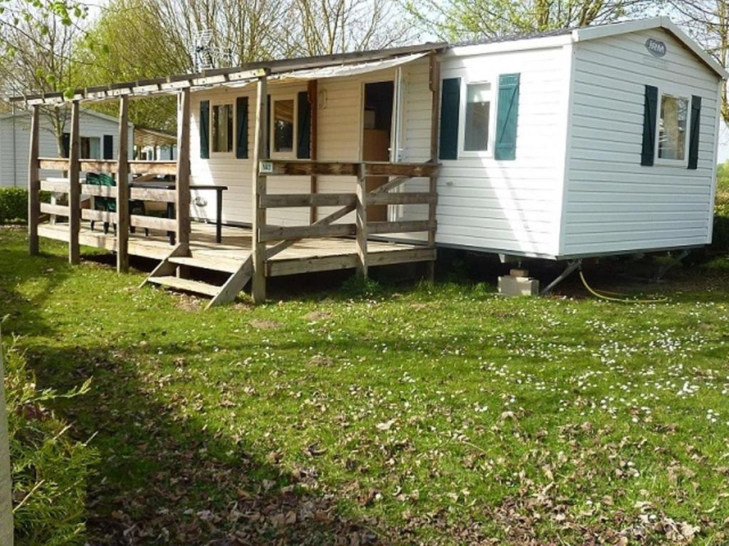 a small white house with a porch on a yard at Mobile Home Hanse in Boofzheim