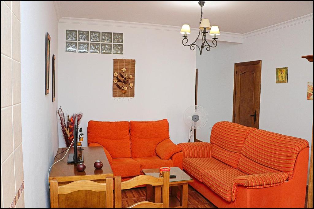 コニル・デ・ラ・フロンテーラにあるApartamento Loyolaのリビングルーム(オレンジ色のソファ、テーブル付)