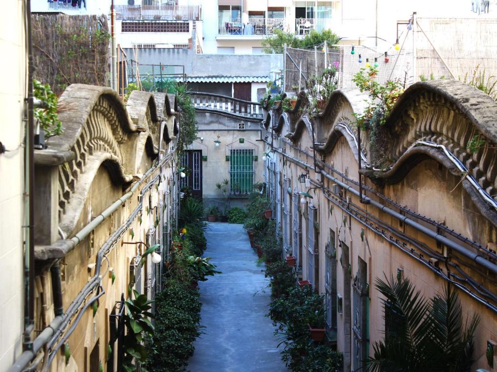 a narrow alley between two buildings with plants at Casa Tortilla Sagrada Familia in Barcelona