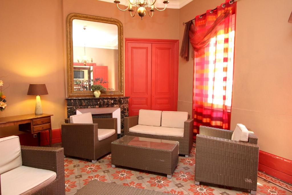 a living room with a mirror and chairs and a fireplace at Logis Hotel Le Clos Des Oliviers in Bourg-Saint-Andéol