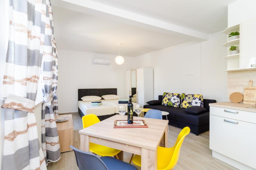 een eetkamer en woonkamer met een tafel en stoelen bij ABC Lapad Apartments in Dubrovnik