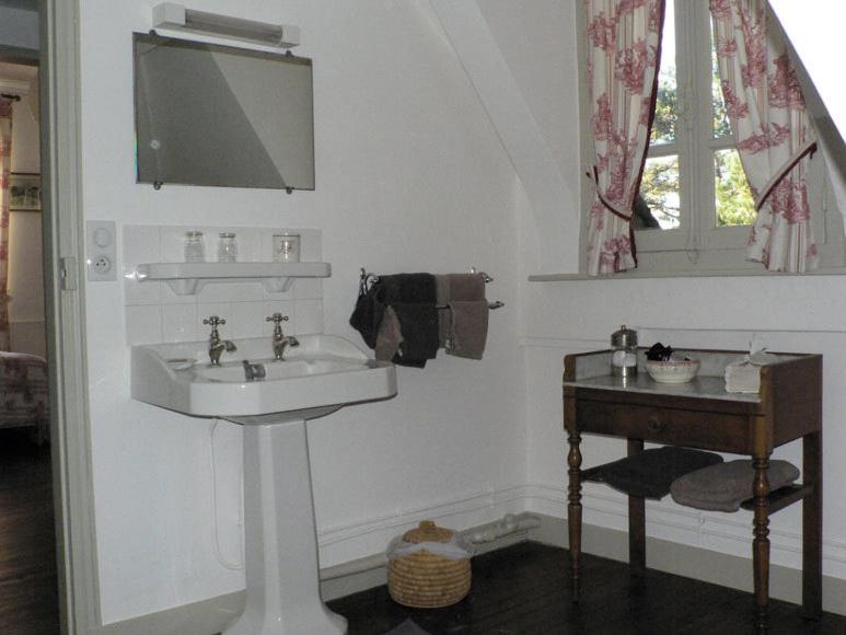 a white bathroom with a sink and a table at Chambres d'Hôtes les Charmettes in Étretat