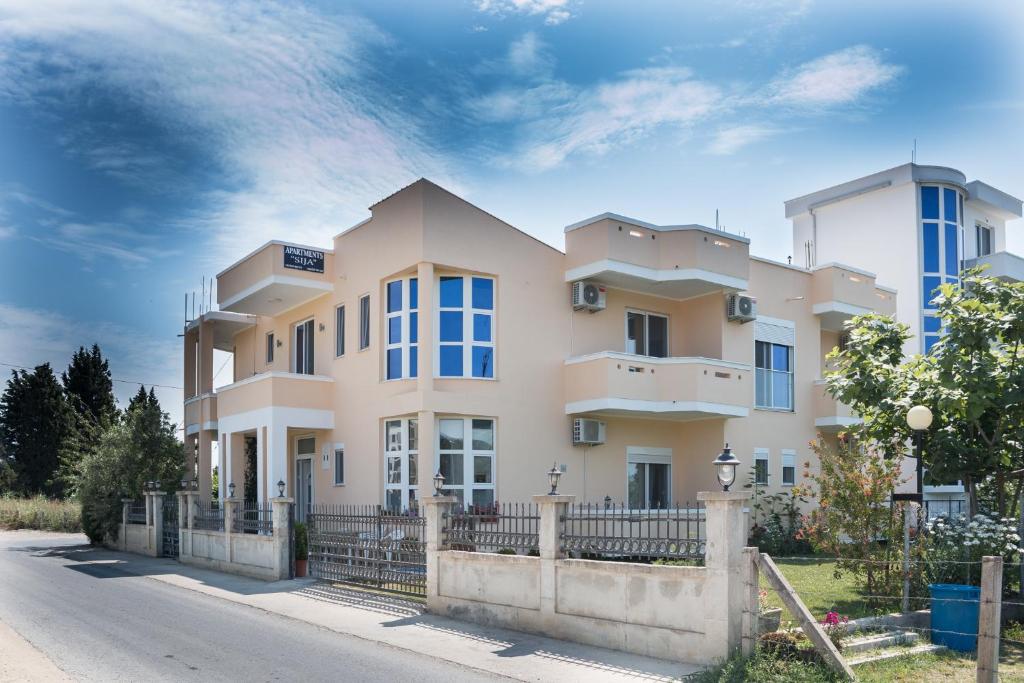 una casa grande con una valla delante en Apartments Sija, en Ulcinj